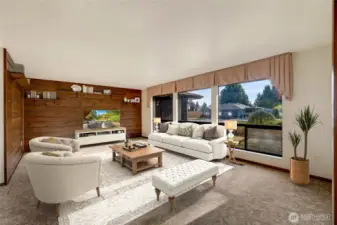 The spacious formal living room is bright and inviting, with sunlight streaming through large windows.  [This photo is virtually staged.]