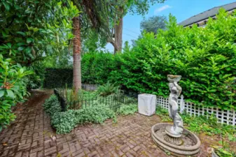 Side yard with water fountain and gate to front yard