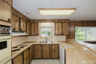 This is such a pleasant kitchen, with double ovens, a dishwasher, and windows to enjoy the green views and abundant wildlife.