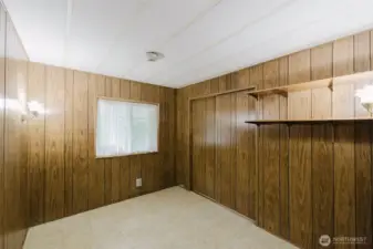 This is the second bedroom, with wall shelving, double closet and wall sconce lighting.