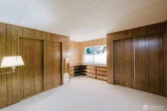Primary bedroom with two double closets and built-in dresser storage under the corner window.