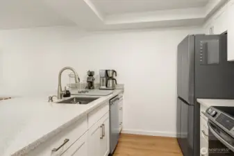 Quartz counters, stainless appliances accentuate this light & bright kitchen.
