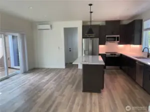Kitchen eating area with slider leading to back deck. Door in background leads to garage and there is a walk-in pantry just to the left of the garage door.
