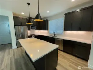 Large island has eating bar. Undermounted cabinet lights give off a special look.