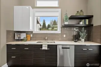 Modern kitchen in a home for sale in the River Rock community, featuring a large center island with seating, quartz countertops, stainless steel appliances, and sleek cabinetry. The open layout, abundant natural light, and connection to the living area create an ideal space for cooking, gathering, and everyday living.