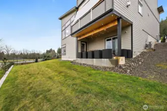 Private backyard with open lawn and views of the surrounding landscape, located behind this Auburn River Rock home. The outdoor space connects easily to the patio, offering room for gatherings, outdoor living, and enjoying the natural setting.