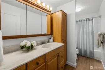 The full bath also got new wide plank LVP and fresh paint to set off the solid oak cabinetry.