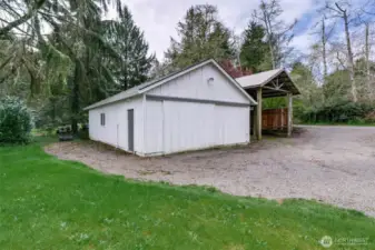 864 sq ft shop with sliding front doors and wooden RV storage structure.
