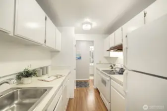 This view of the kitchen shows that the bathroom is just across the hallway, convenient for whoever is cooking dinner, but off the beaten path for privacy when you have guests.