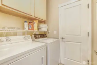 Laundry room with a full size washer and dryer, plus additional cabinet space.