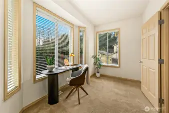 Wide glazed doors and expansive windows bring the outdoors in, reinforcing the home’s connection to its landscaped surroundings.