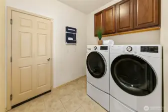 Dedicated laundry room featuring LG ThinQ washer and dryer with steam functionality and added storage for everyday efficiency.