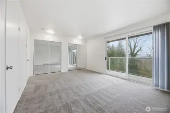 Another view of the primary boasts large mirrored door closets.