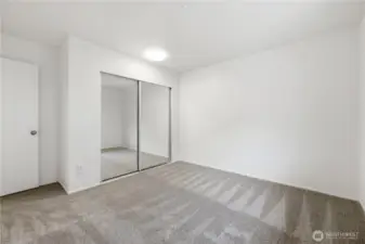 Another view of the upstairs guest bedroom with mirrored closet doors.