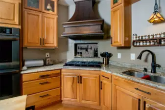 Beautiful copper range hood is a center piece in this gourmet kitchen.