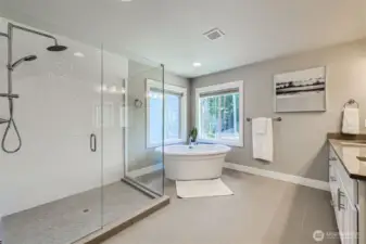 Spa-like primary bath with custom, oversized shower and designer stand-alone soaking tub.