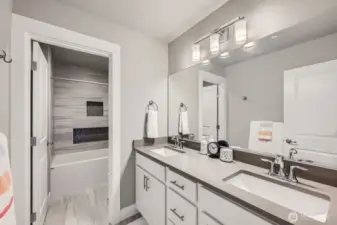2nd Story Full Bath with quartz counters and built-in accent tile shelves in shower.