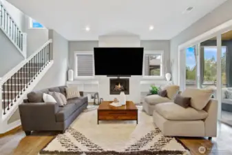 Elegant, modern and full of sunlight - Family room with dramatic windows, electric fireplace and covered verands overlooking a wall of forest trees.