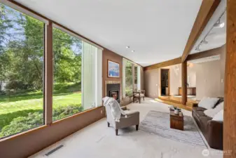 Formal living room features large windows overlooking the spacious lawn.
