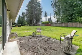 Back patio and partially fenced yard.