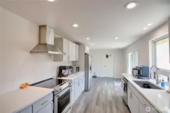 Galley kitchen leads to laundry room w/ half bath and garage