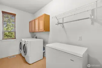 Laundry room with cabinetry and a window!  Washer, dryer and freezer may be included in the sale.