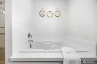 A generous soaking tub in the primary bathroom adds a relaxing, spa-like touch.