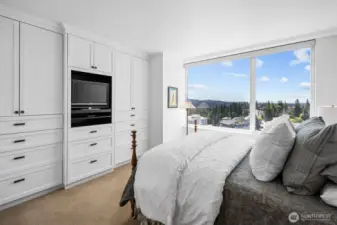 Primary bedroom with large windows capturing city and mountain views.