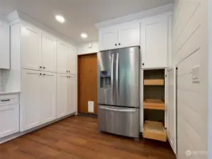 More pullouts and cabinet space next to the top-of-the-line refrigerator. Garage door to the left makes it easy to bring in the groceries and be able to put them away quickly and efficiently.