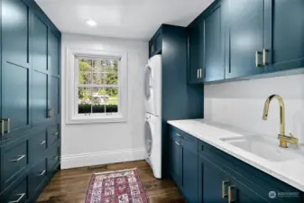 Laundry room with custom cabinetry quartz counters and sink.