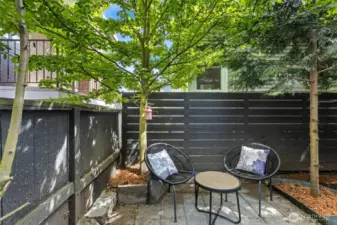 Backyard features a patio and an area for gardening and pots.