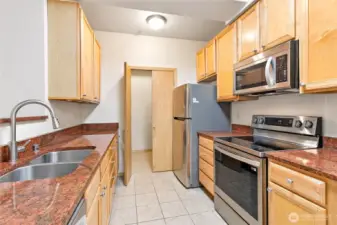 Laundry and shelf lined pantry through doors