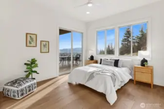 The primary suite is on the main level and is spacious and bright. Note the access to the deck