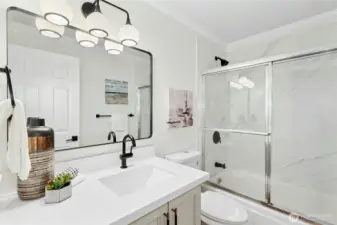 Updated bathroom includes: new vanity, new flooring, new lighting, and new tile surround!