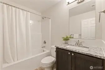 Full Bathroom off the hallway with upgraded stone countertop, under-mount sink & tile backsplash.