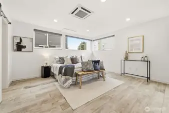 Oversized and air conditioned primary suite with sitting area, spacious custom closet, and heated tile floors in the primary bath.