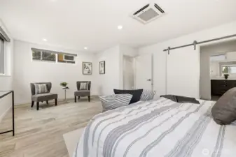 Oversized and air conditioned primary suite with sitting area, spacious custom closet, and heated tile floors in the primary bath.