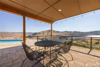 Patio wraps around two sides of the house to capture the scenery below and the pool along side.