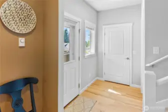 Vestibule at front porch and stair to upper level with guest coat closet.
