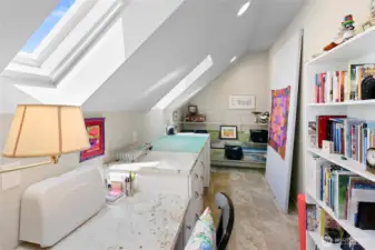 Spacious studio or den features skylight with insulating shade.