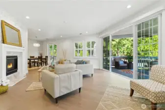 Living room flows into dining area- windows offer custom plantation shutters, upscale shades and sliding glass doors to invite the outside in!