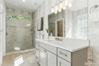 Separate walk in shower with tiled floor and walls and tempered glass door. The separate commode room is to the left of the shower.