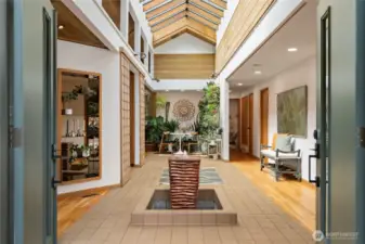 A freshly painted exterior and the double-door entry leads you into a dramatic and unique skylight atrium with a fountain - truly a one-of-a-kind space!