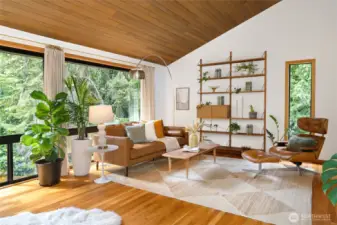 The spacious living room looks out to serene treed views through large picture windows.