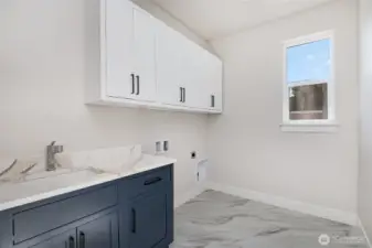 Generous laundry room on upper level, includes sink and plenty of storage