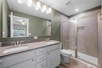 Light and bright primary bath with a large walk-in shower and modern finishes.