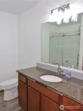 Bathroom w/ slab granite counters.