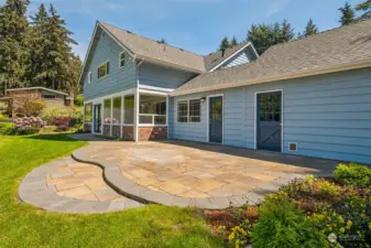 Constructed in 2023, this exquisitely crafted stone patio is an ideal setting for hosting outdoor gatherings. Seamlessly connected to the sunroom through double doors, it beckons you to step outside and bask in the beauty of nature. To the east, a garden area used for raspberries and strawberries.