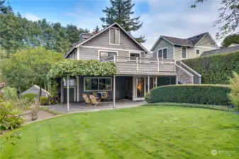 Lush gardens, gracefully covered by wisteria and bordered with elegant stone pavers, creating a serene and picturesque outdoor setting.