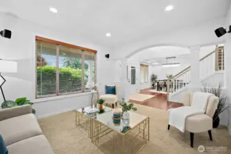 The formal living area boasts an arched entry with columns to accentuate the room transition.